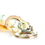 image of a bottle of alcohol and handcuffs