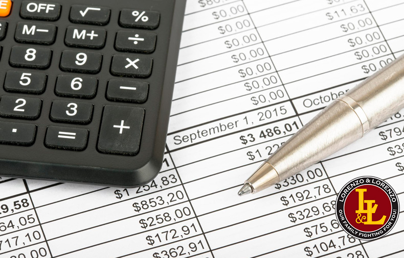 close-up of calculator and pen on top of spreadsheet